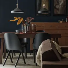Elegancka jadalnia w odcieniach brązu. Drewniany stół, czarne krzesła i komoda tworzą przytulną atmosferę.