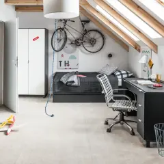 Pokój ze skosem młodzieżowy z rowerem pod sufitem, łóżkiem, biurkiem i regałem.