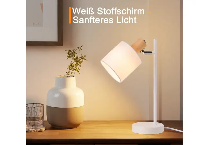 Stylowa lampka nocna z kloszem z białego materiału i elementami z drewna. Delikatne światło rozświetla stolik nocny.