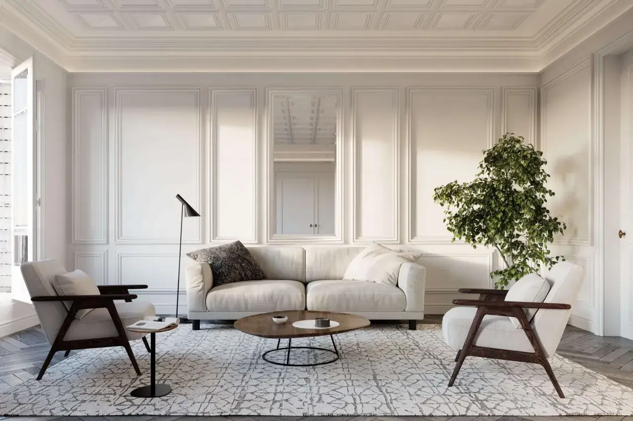 Elegancki salon w ciepłych odcieniach bieli, z wygodną sofą, fotelami i stolikiem kawowym.